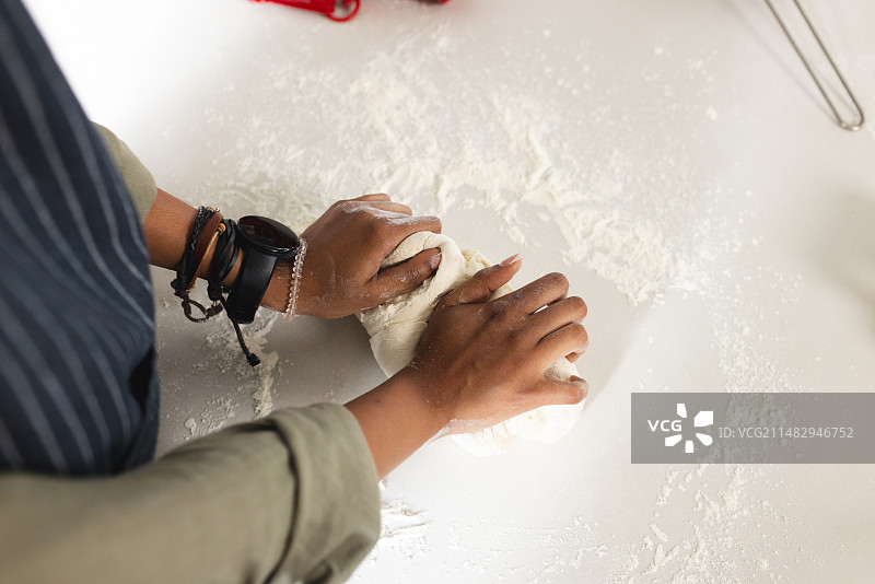 在撒满面粉的表面上揉面团，展示烘焙过程图片素材