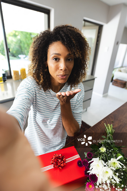 混血女人在家中通过视频通话收到礼物图片素材
