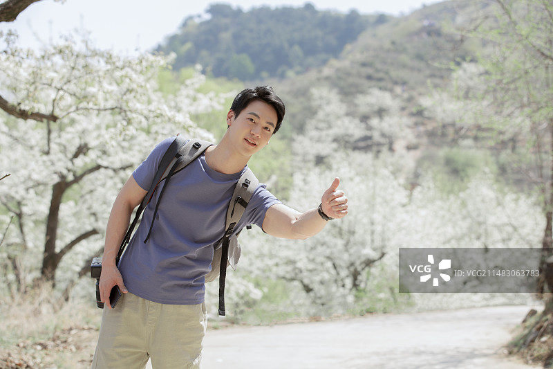 青年男子户外旅行做手势打车图片素材