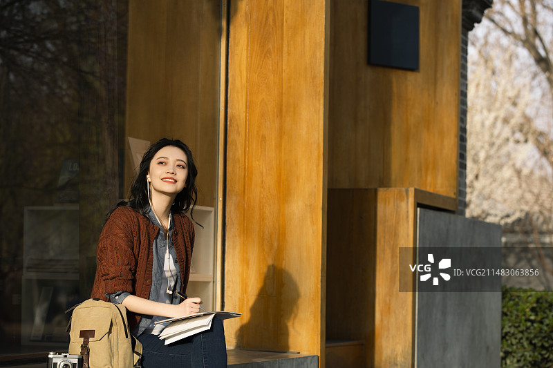 青年女子城市旅行听音乐写生画画图片素材
