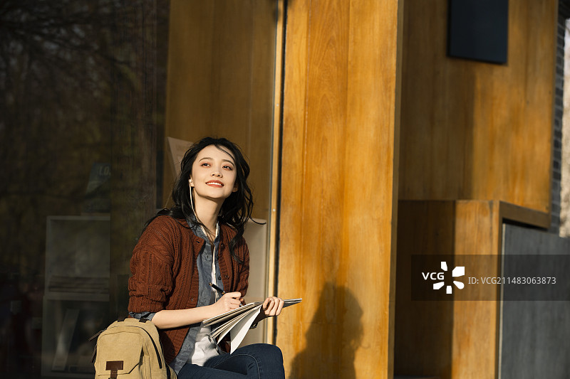 青年女子城市旅行听音乐写生画画图片素材