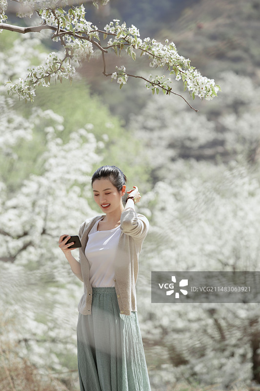 青年女子户外旅行看手机图片素材