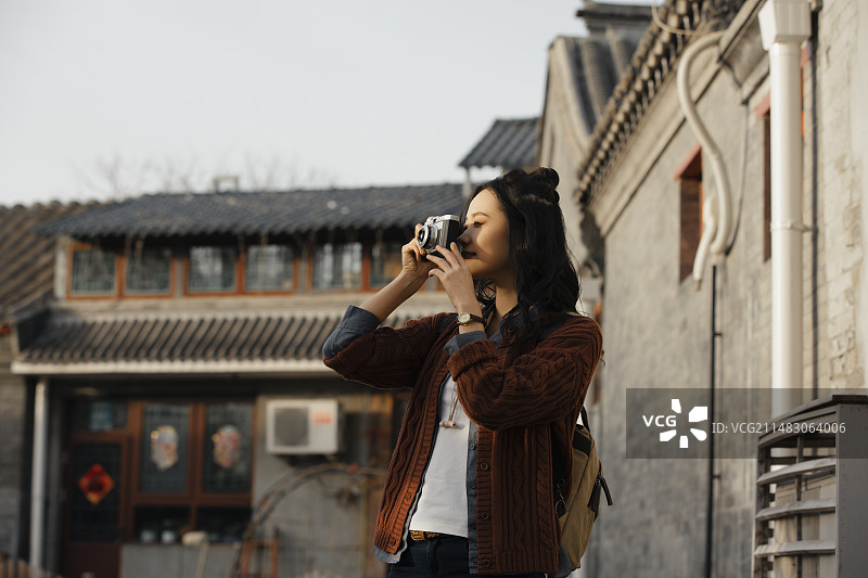 青年女子在城市胡同旅行拍照图片素材