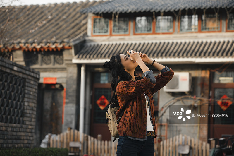 青年女子在城市胡同旅行拍照图片素材