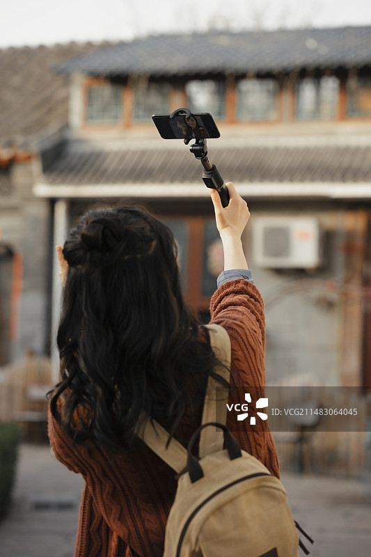 青年女子视频直播城市胡同旅行图片素材