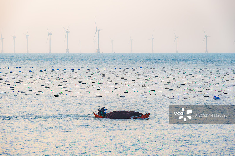 清晨海上驾船劳作的渔民图片素材