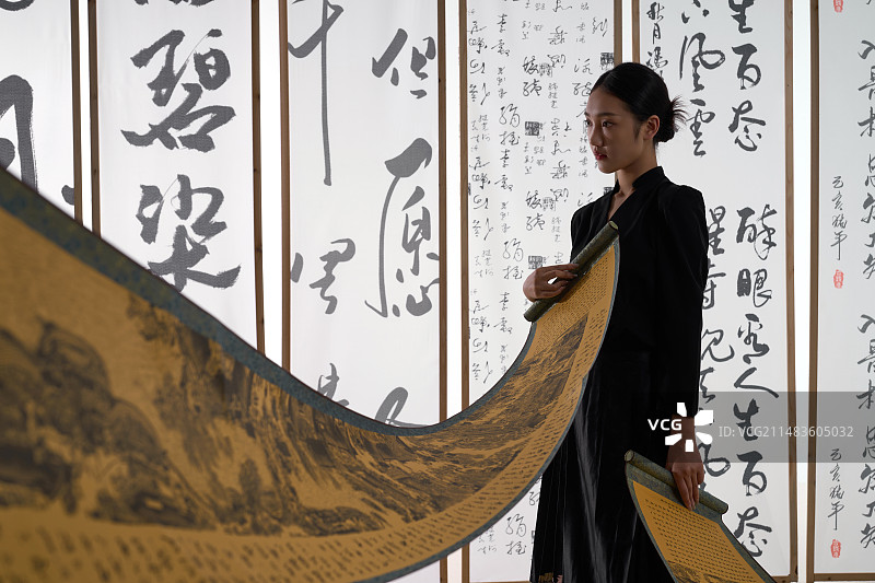 一位身穿民族服饰美女拿着古典式卷轴图片素材