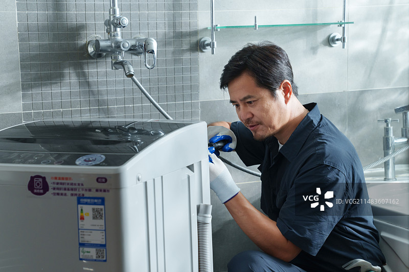 专业的修理工维修安装洗衣机图片素材