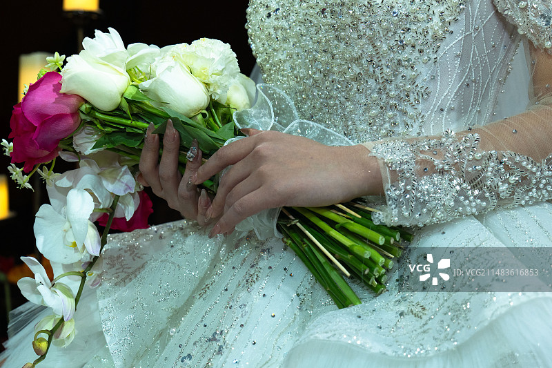 女子身穿白色礼物手捧鲜花的特写图片素材