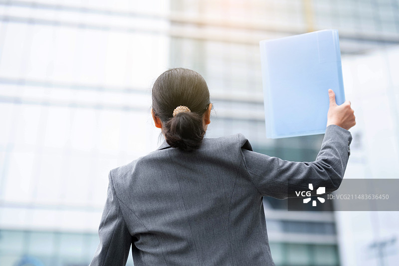 手拿简历求职的女性背影图片素材