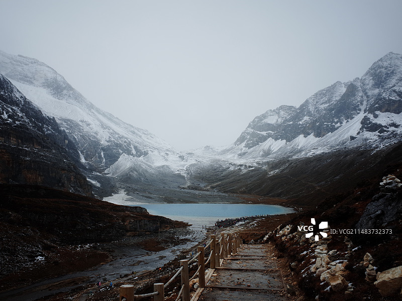 稻城亚丁牛奶海白雪皑皑的群山映衬下的湖景图片素材