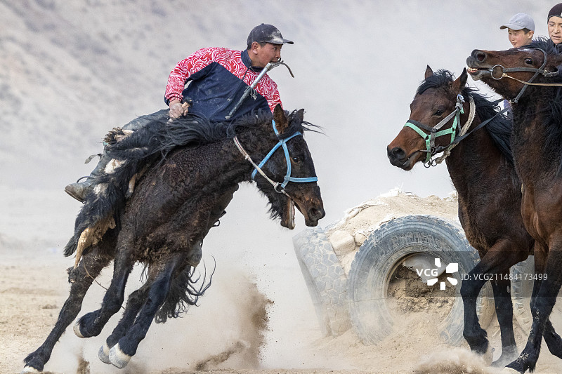 在诺鲁孜节的柯克-勃鲁（或 U拉克-塔提什或布兹卡奇）比赛中的骑手，中亚马术比赛，科奇科尔，纳伦地区，吉尔吉斯斯坦图片素材