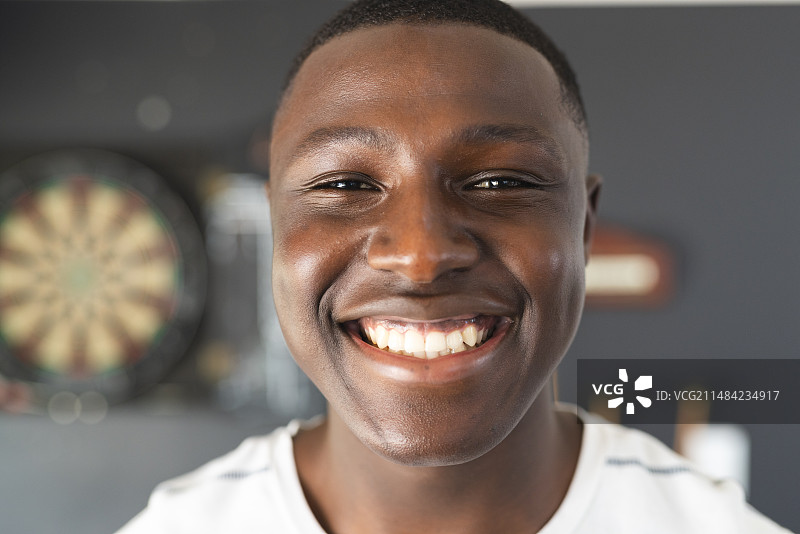 一位笑容灿烂、身穿白衬衫的年轻非裔美国男人图片素材