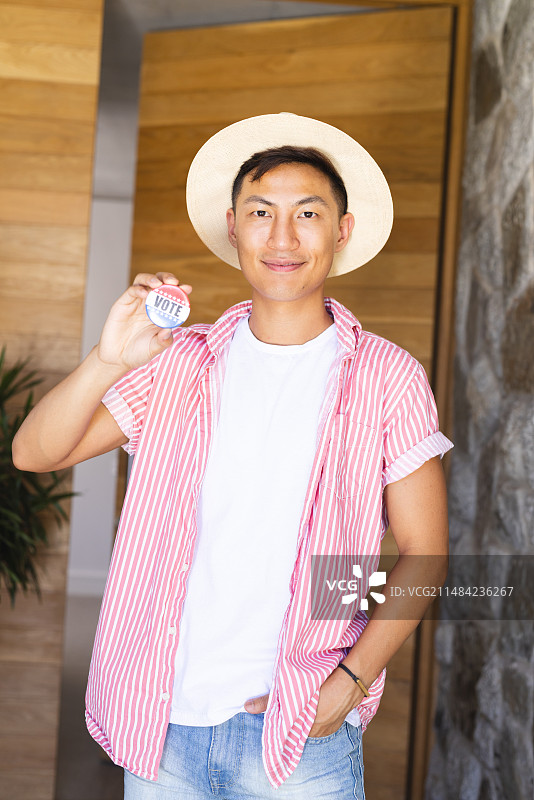 亚洲男人手持“投票”徽章展示图片素材