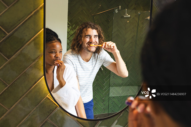 多元情侣一起刷牙，年轻的非裔美国女人和年轻的白人男人图片素材