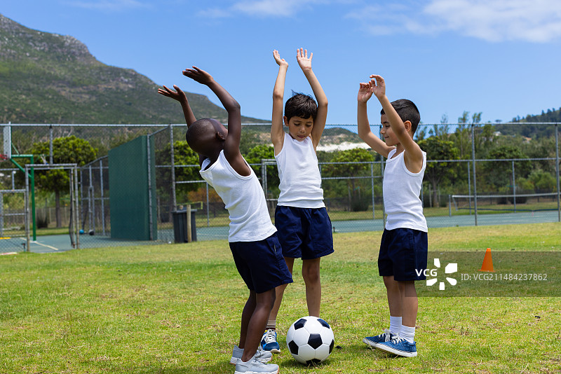 学校足球比赛中庆祝的三名男孩图片素材