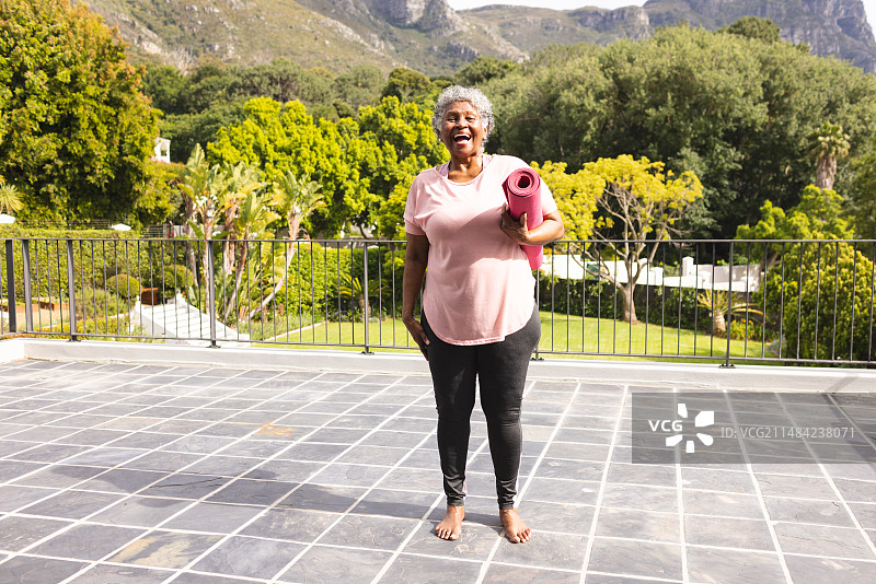 老年女人户外手持瑜伽垫微笑图片素材