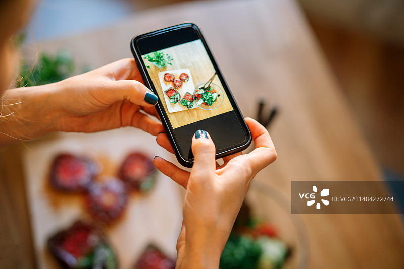女子在厨房拍摄食物，西班牙莱里达图片素材
