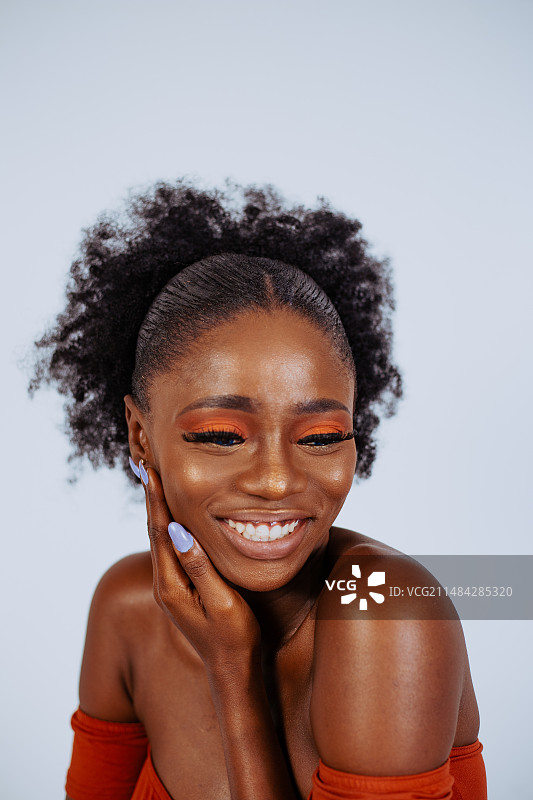 在白色背景下双手抱头的微笑年轻女子肖像图片素材