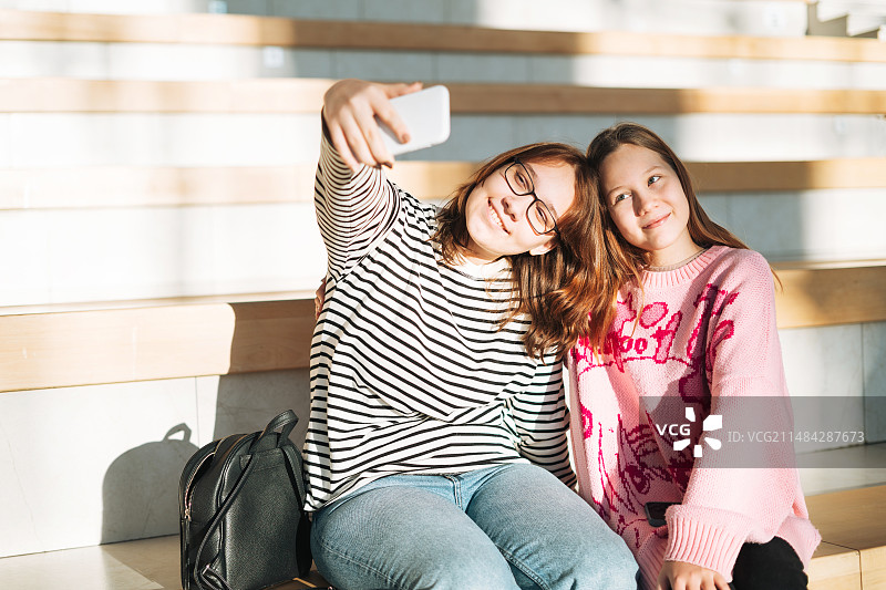 坐在楼梯上用手机自拍的青少年，俄罗斯斯维尔德洛夫斯克州叶卡捷琳堡图片素材