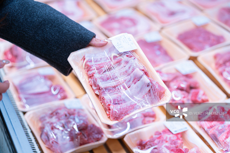 市民在超市保鲜柜里挑选新鲜猪排骨图片素材