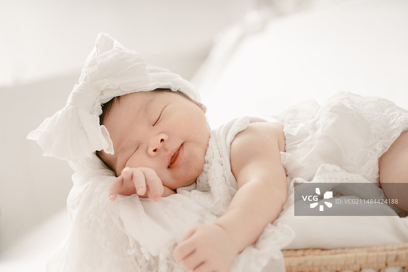 婴儿篮中甜睡的天使宝宝的脸部表情图片素材