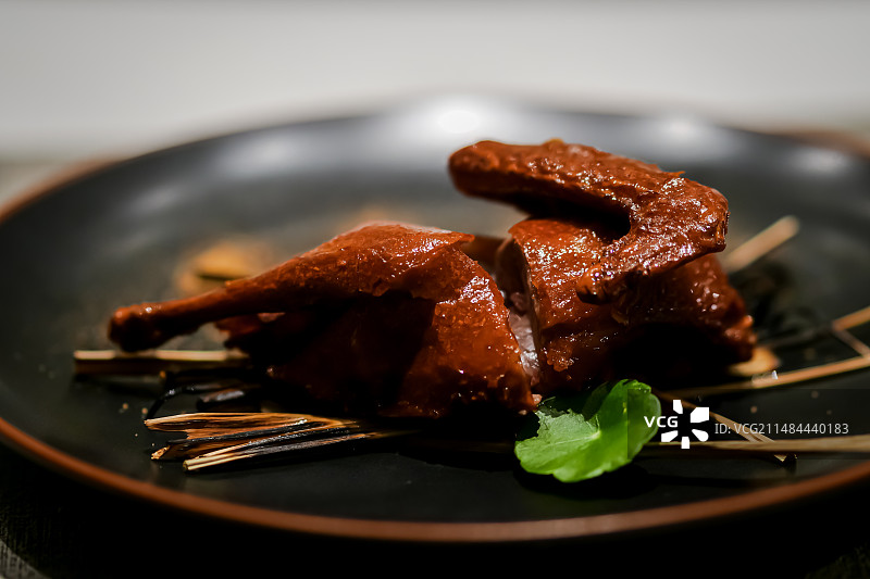 桌上盘子里的红烧乳鸽的特写镜头图片素材