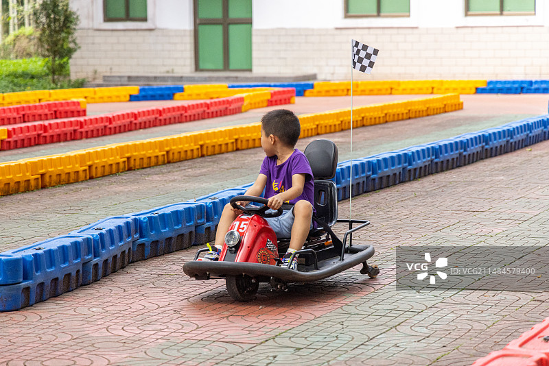 小男孩在海南琼海红色娘子军纪念馆里的游乐场玩赛车图片素材