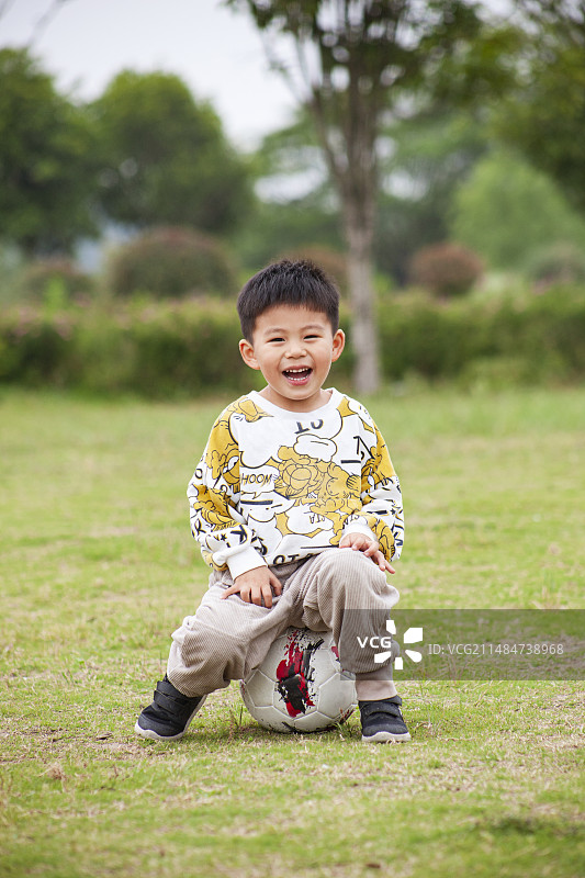 草地上踢足球的小男孩图片素材