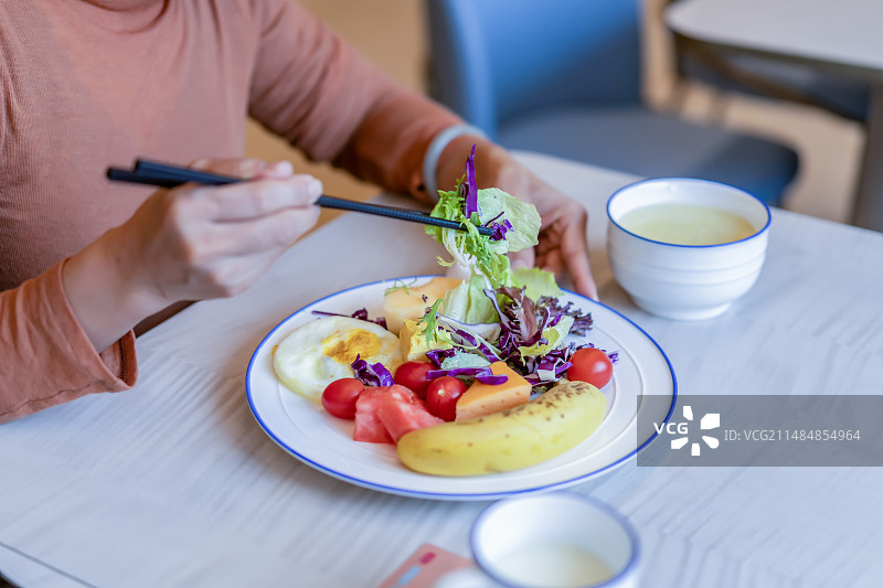一个女性在食用水果和蔬菜沙拉图片素材