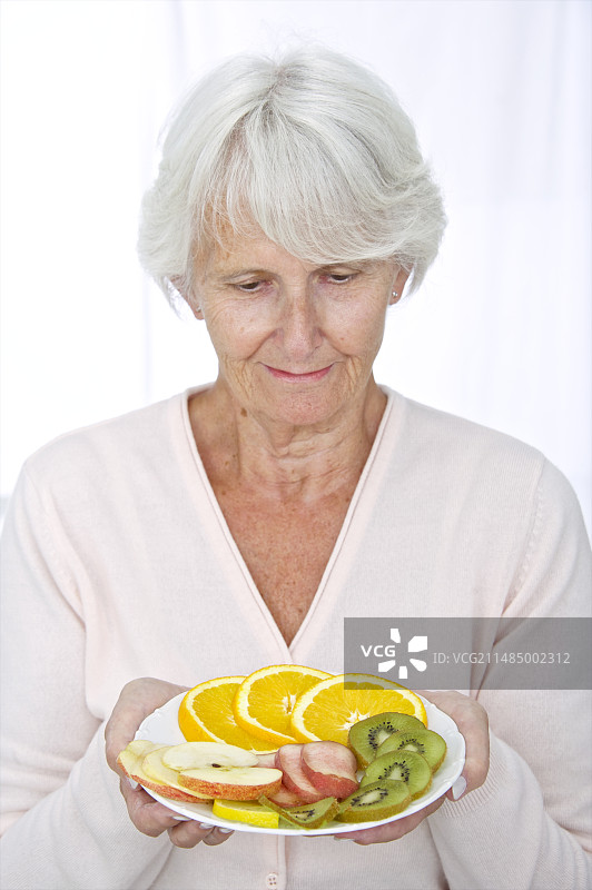 手持水果的老年妇女图片素材