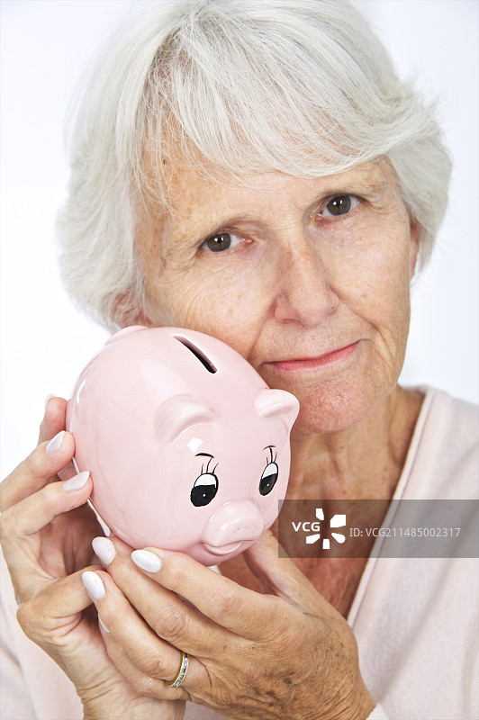 拿着储蓄罐的老年妇女图片素材