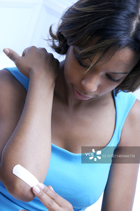 女人在伤口上贴膏药图片素材