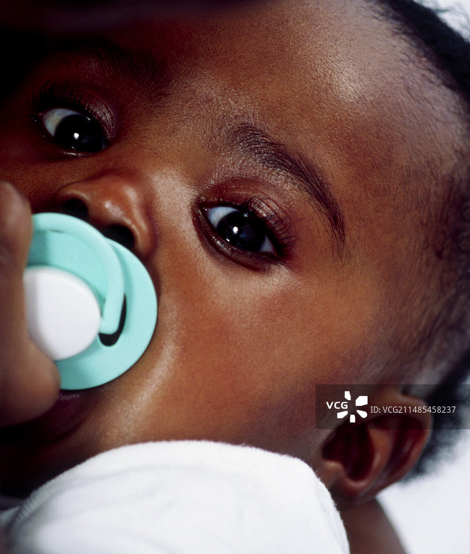 正在吸奶嘴的女婴图片素材