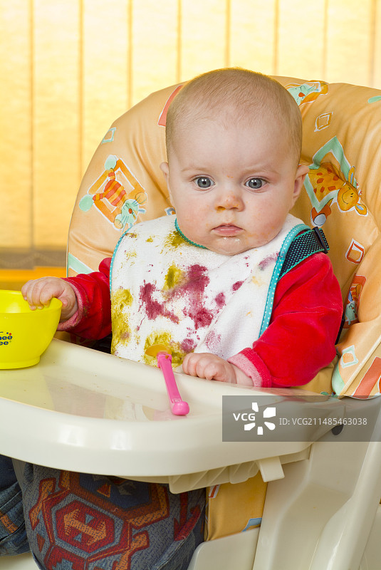 坐在高脚椅上吃东西的婴儿图片素材