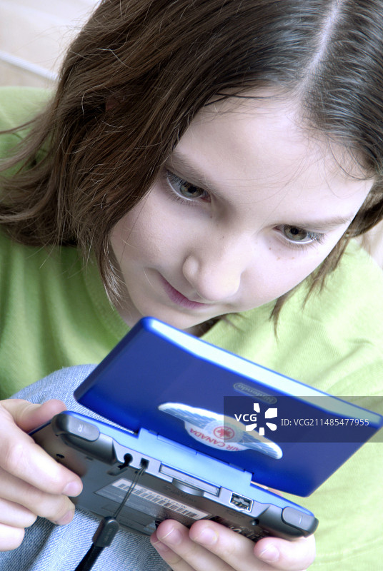 在游戏机上玩耍的女孩图片素材