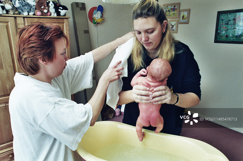 给新生男婴洗澡图片素材
