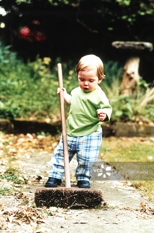 男孩正在使用扫帚图片素材