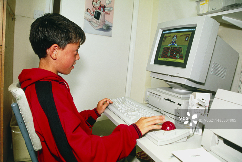 男孩在个人电脑上玩耍图片素材