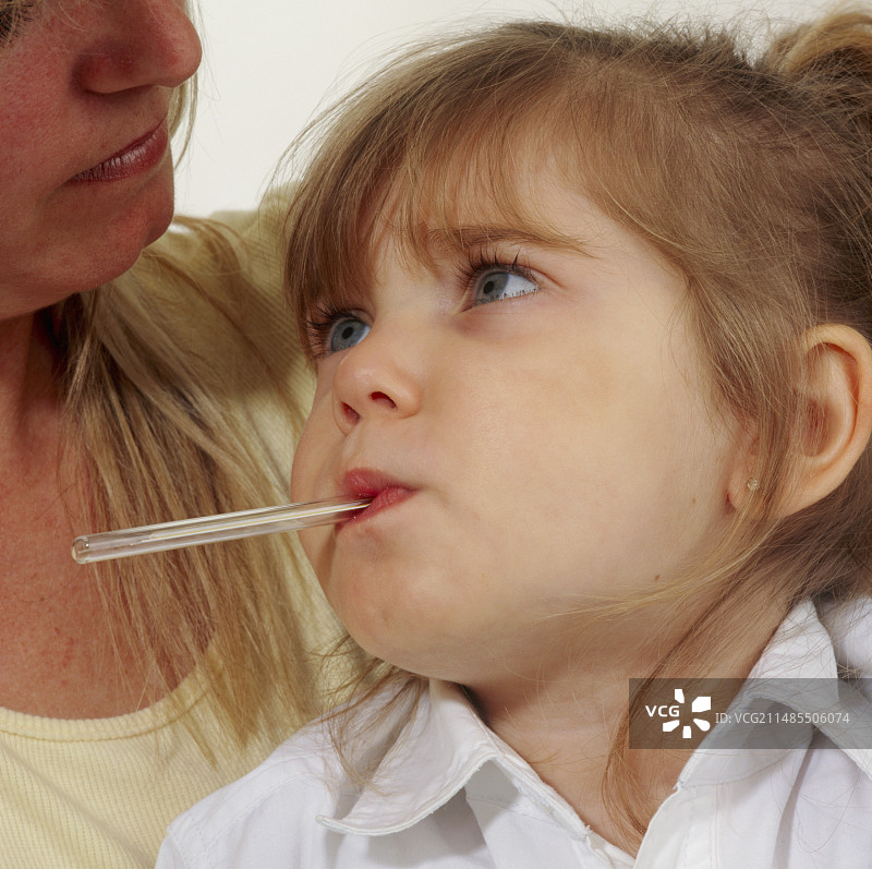 发烧的年轻女孩正在测量口腔温度图片素材
