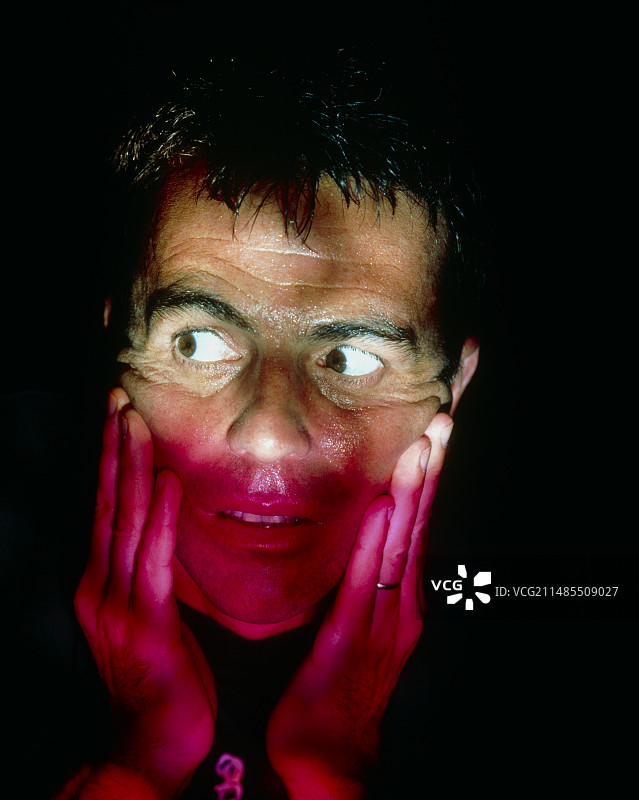 黑暗中男人因恐惧而流汗的面部表情图片素材