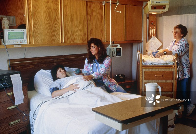 孕妇在分娩室，由护士照料图片素材