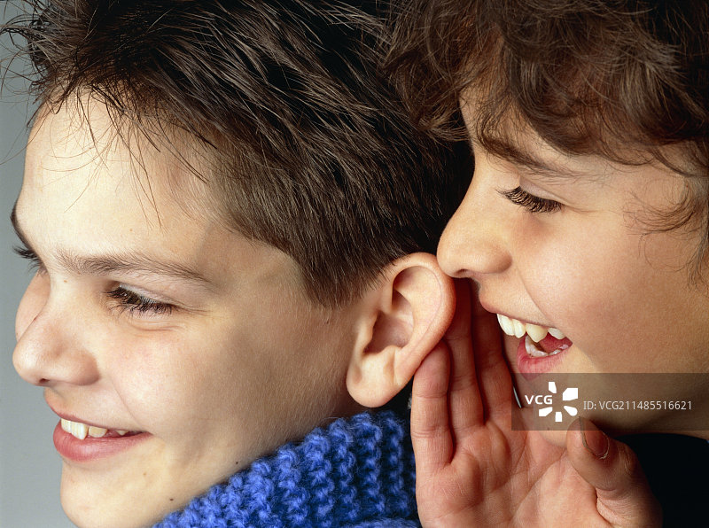 男孩在另一个人耳边低语图片素材