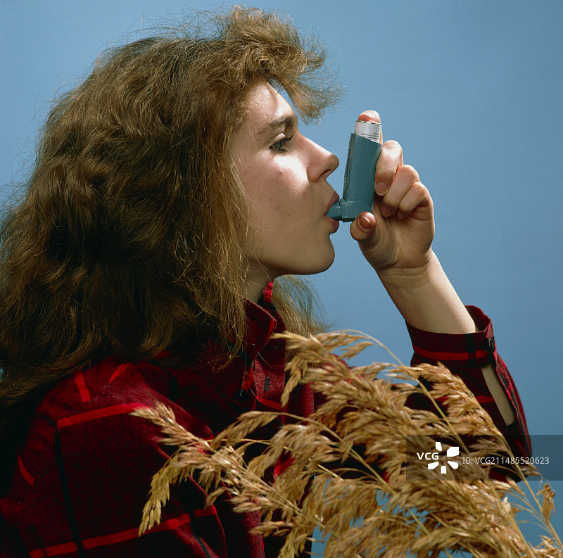 小女孩使用呼吸素吸入器治疗哮喘图片素材