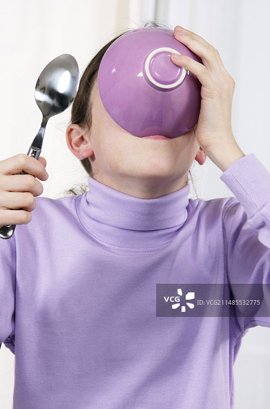 正在用碗喝东西的女孩图片素材