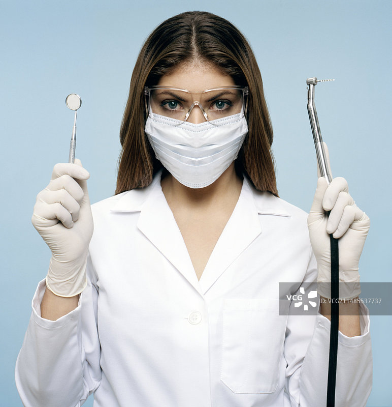 牙医拿着镜子和钻头图片素材