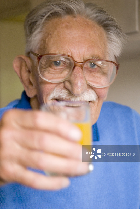 年长的男人拿着一杯果汁图片素材