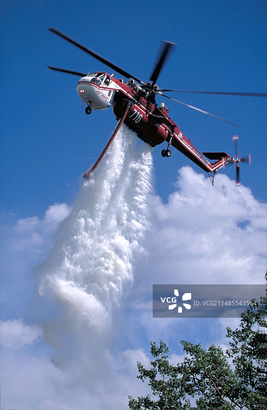 直升机向森林火灾区洒水图片素材