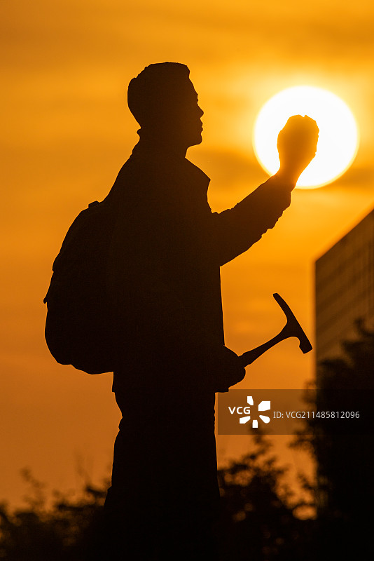 中国地质大学校园内的地质勘探队员雕像与夕阳落日同框图片素材