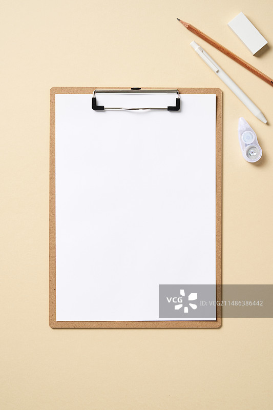 浅黄色粉彩背景的剪贴板和书写工具图片素材